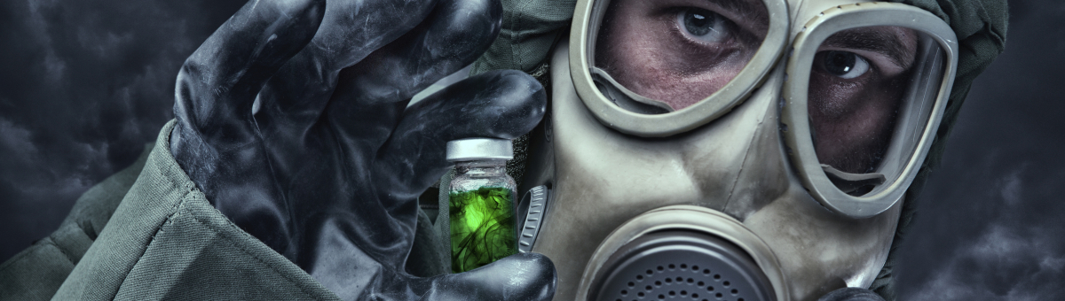 Man in hazmat suit, holding vial with green liquid