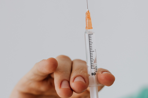 A person holding needle and syringe