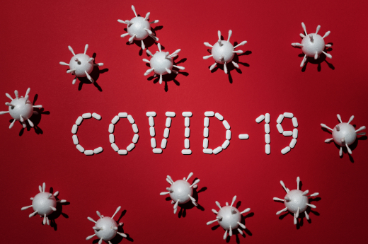 Red background Covid 19 written out surrounded by microbes